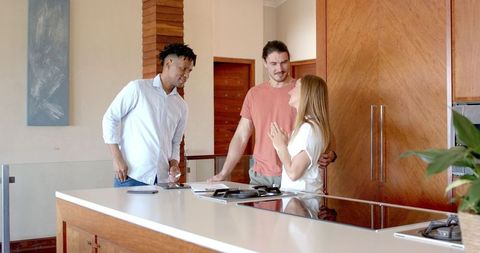 Friends Joyfully Planning in Modern Kitchen Setting