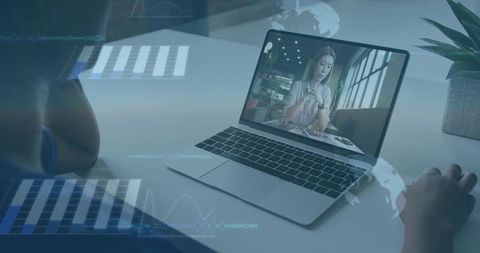 Remote professional watching virtual meeting on laptop with data overlays, charts