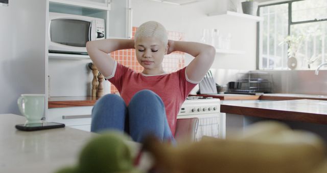 Relaxing at Home: Young Woman in Kitchen with Hands Behind Head - Download Free Stock Images Pikwizard.com