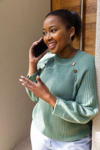 Smiling Woman Chatting on Smartphone in Casual Setting