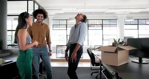 Colleagues enjoying unpacking office supplies for new workspace