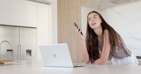 Teenager Engaging with Technology in Modern Kitchen