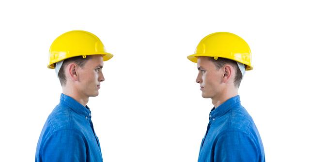 Two male engineers in yellow hard hats and blue shirts are facing each other against a white background. This image can be used for themes related to teamwork, collaboration, construction, safety regulations, and professional planning in engineering projects. Ideal for use in promotional materials, training manuals, or industry-focused articles.