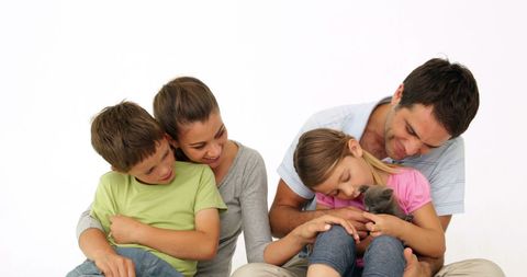 Happy Family Enjoying Time with Adorable Kitten at Home