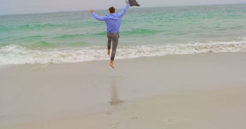 Businessman Jumping on Beach for Stress Relief