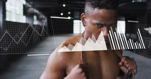 Shirtless athlete holding heavy battle rope training in industrial gym fitness data overlay
