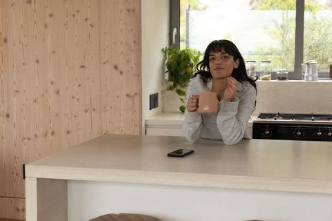 Relaxed woman with mug in contemporary kitchen