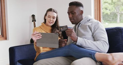 Couple Shopping Online with Tablet and Credit Card on Cozy Sofa