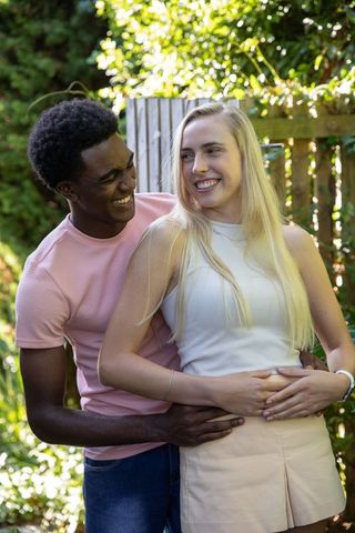 Romantic Couple Embracing in Lush Backyard Garden