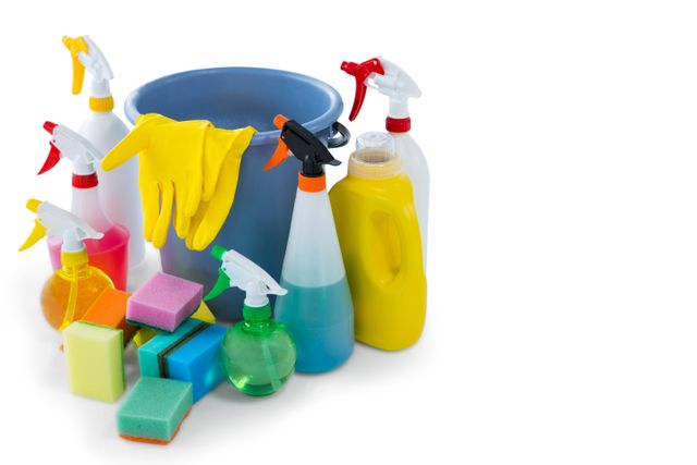 Assorted cleaning supplies including a blue bucket, colorful sponges, spray bottles, yellow gloves, and detergent arranged on a white background. Ideal for use in advertisements, articles, and websites related to household cleaning, sanitation, and hygiene. Perfect for illustrating cleaning tips, product promotions, and home maintenance guides.