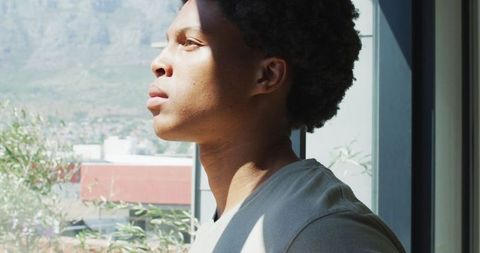 African american man enjoying morning coffee by window