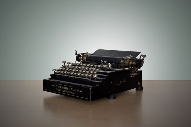Depicts vintage manual typewriter placed on wooden desk. Useful for themes related to nostalgia, historical writing tools, and retro office settings. Ideal for illustrating articles about history of writing, old-school journalism, or retro home decor.