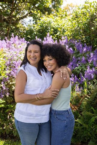 Mother and Daughter Embracing in Blooming Garden Outdoor