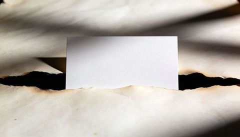 Blank Card Emerging from Torn Aged Paper with Dramatic Shadows, Texture and Negative Space