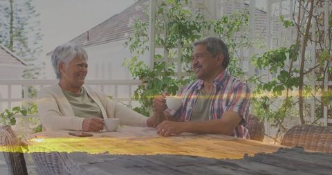 Senior couple enjoying coffee and conversation on sunny porch
