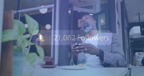 Man in Cafe Checking Social Media Follow Count
