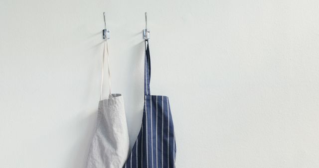 Two Aprons Hanging on Wall with Simple Hooks - Download Free Stock Images Pikwizard.com