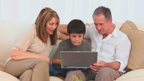 Family Engaged Together Using Laptop at Home