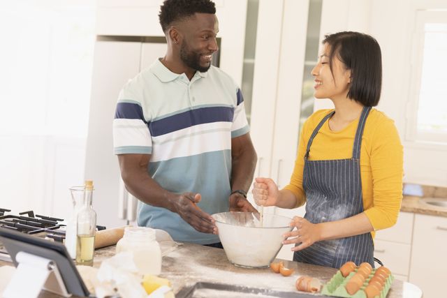 Man and woman cooking together in modern kitchen, bonding and enjoying quality time. Perfect for use in advertisements promoting home life, cooking brands, relationship blogs, or lifestyle magazines.