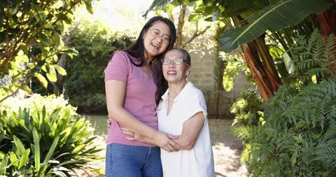 Asian Mother and Daughter Smiling in Beautiful Garden Setting