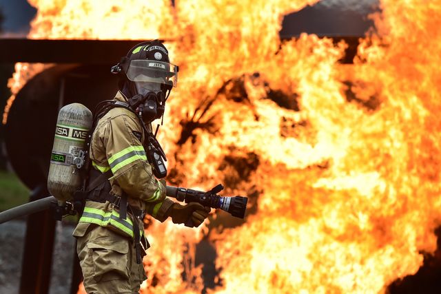Brave Firefighter Battling Intense Blaze with Hose - Download Free Stock Photos Pikwizard.com