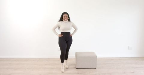 Confident woman posing indoors in stylish outfit