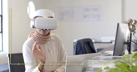 Woman in headscarf exploring vr technology in modern office