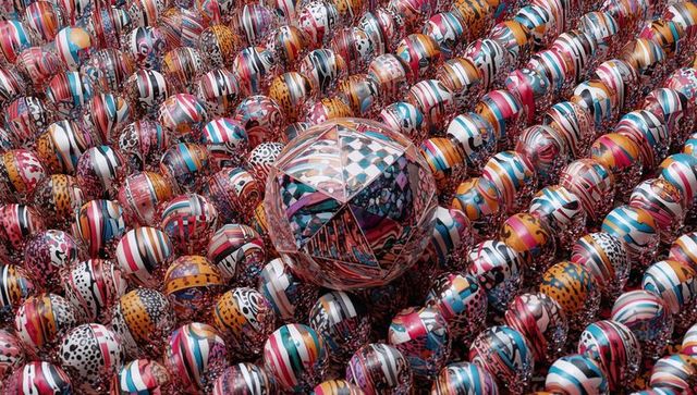 Colorful patchwork spheres creating geometric rhythm around central faceted orb