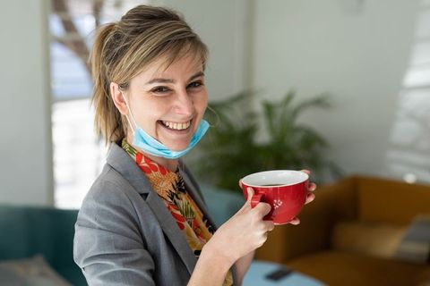 Smiling Professional Woman in Office Lounge with Coffee Mug