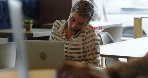 Focused Woman with Laptop at Café Finding Inspiration