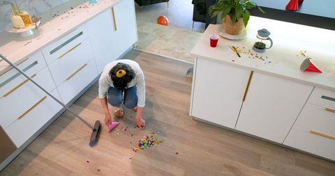 Woman cleaning messy kitchen after celebration