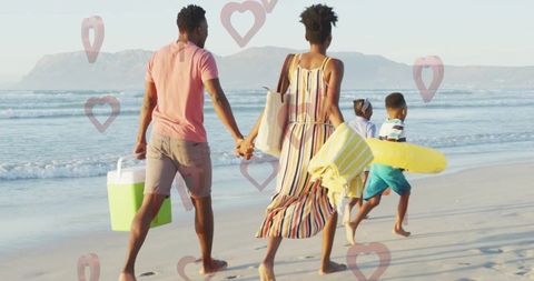 Family enjoying summer day walking along sunny beach