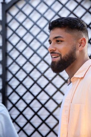 Man chats on patio by decorative lattice fence