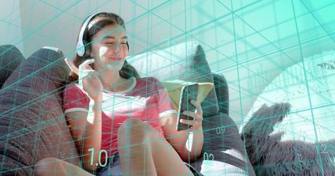 Young woman relaxing on sofa with headphones and smartphone, teal digital grid overlay