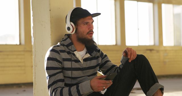 Man with Beard Listening to Music Wearing Headphones and Striped Hoody - Download Free Stock Images Pikwizard.com