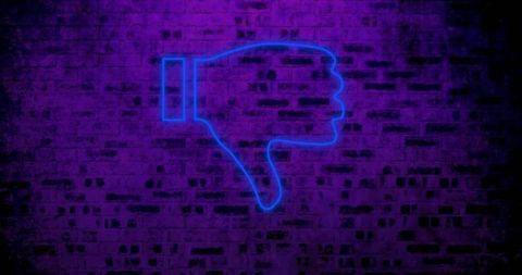 Neon thumbs down sign on brick wall symbolizing rejection