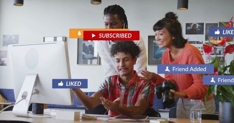 Creative team reacting to social media engagement with camera and desktop notifications