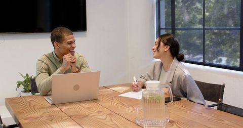 Multiracial colleagues discussing work in modern office meeting