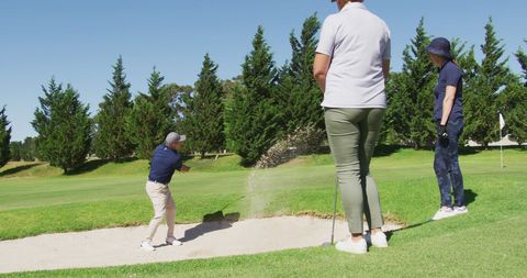 Senior Man Playing Golf from Sand Trap on Sunny Day