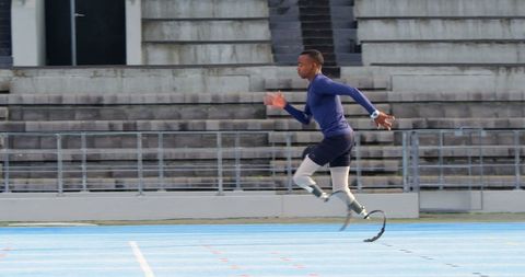Athlete with prosthetic leg sprinting on track
