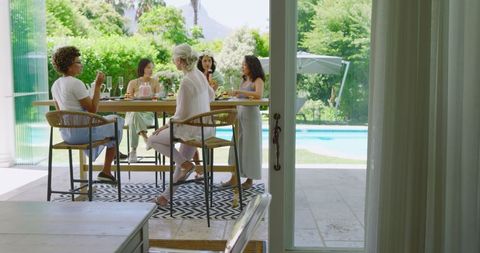 Women Enjoying Lively Brunch Gathering by Pool on Delightful Day