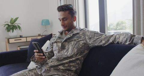 Soldier Relaxing on Couch Checking Smartphone