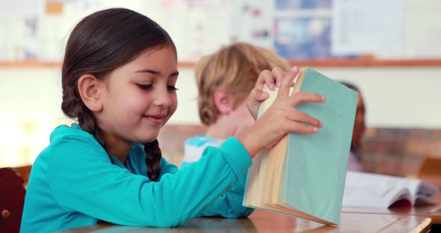 Smiling Elementary School Girl Reading Book in Classroom - Download Free Stock Images Pikwizard.com