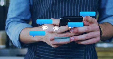 Barista tapping smartphone with floating chat bubbles over coffeehouse counter cozy hands