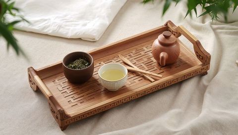Bamboo tea tray featuring yixing clay teapot cup serving loose leaf green tea ritual
