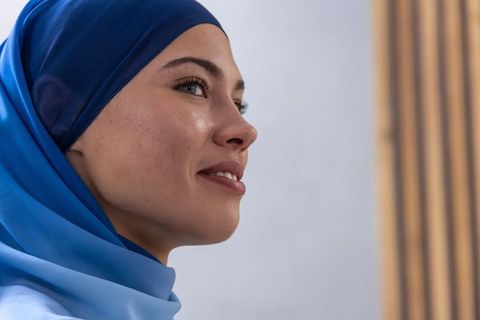 African american woman in blue hijab looking contemplative and confident closeup