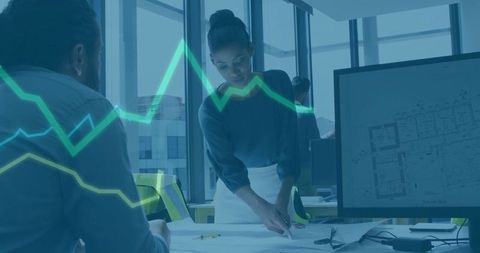 Female Architect Pointing at Blueprint During Team Collaboration with Data Graph Overlay