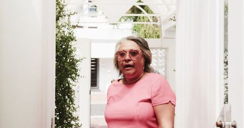 Senior woman on vacation enjoying arrivals at hotel entrance