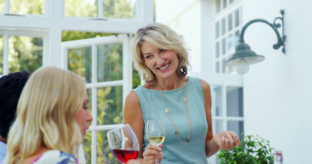 Smiling Mature Woman Socializing with Friends Over Wine - Download Free Stock Images Pikwizard.com