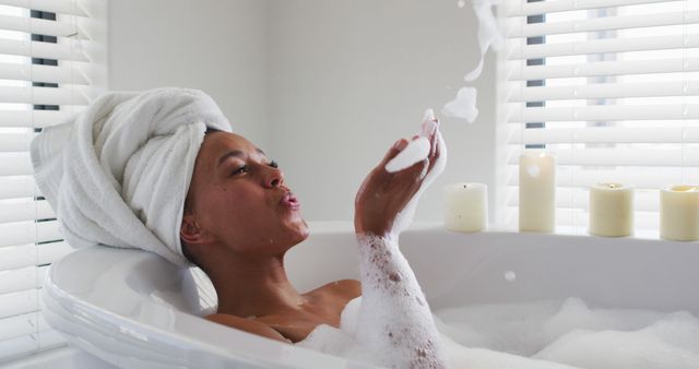 Woman Relaxing in Bathtub with Candles Blowing Bubbles - Download Free Stock Images Pikwizard.com